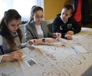 Zdjęcie przedstawia trójkę dzieci zastanawiające się nad zadaniem.
