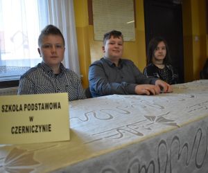 Zdjęcie przedstawia trójkę dzieci siedzących przy stole.