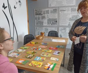 Na zdjęciu widoczne są dwie osoby przeglądające kartki wielkanocne.