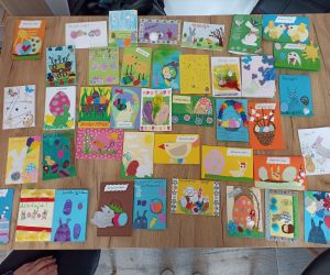 Zdjęcie przedstawia rozłożone na stole kartki wielkanocne.