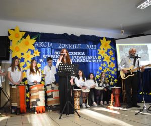 Zespół śpiewa i gra na scenie.