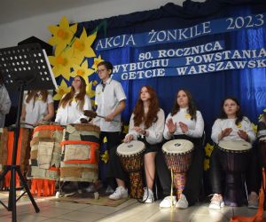 Zespół śpiewa i gra na scenie.