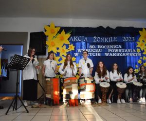 Zespół śpiewa i gra na scenie.