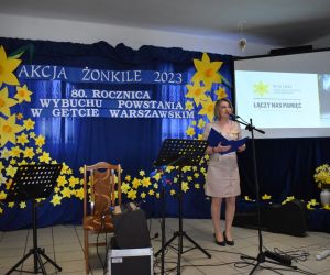 Osoba wewnątrz budynku przemawia do mikrofonu.