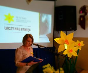 Osoba wewnątrz budynku przemawia do mikrofonu.