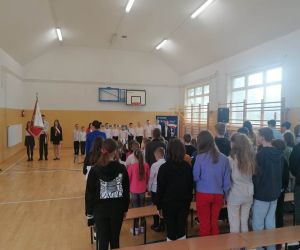 Uczniowie szkoły stoją podczas śpiewania hymnu państwowego
