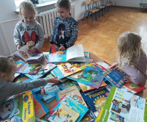 Dziewczynki rozmawiają o książkach przy stoliku z książkami