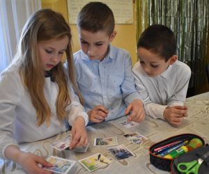 Na zdjęciu widoczne są dzieci rozwiązujące zadania.