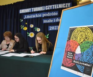 Na zdjęciu widoczna jest komisja konkursowa siedząca przy stole.