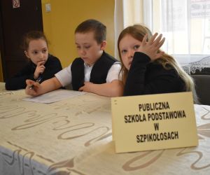 Na zdjęciu widoczne są dzieci siedzące przy stole.