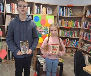 Zdjęcie przedstawia dwoje dzieci pozujących z książkami.