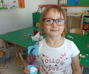 Zdjęcie przedstawia dziewczynkę pozującą z zakładką.