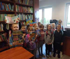 Na zdjęciu widoczna jest grupa dzieci pozująca z książkami