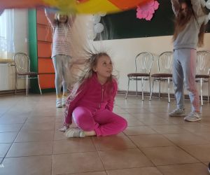 Zdjęcie przedstawia dzieci bawiące się chusta animacyjną.