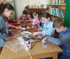 Zdjęcie przedstawia dzieci wykonujące pracę plastyczną.