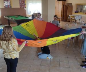 Zdjęcie przedstawia dzieci bawiące się chusta animacyjną.