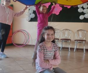 Zdjęcie przedstawia dzieci bawiące się chustą animacyjną.