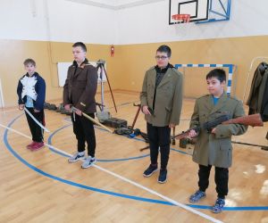 Czterech uczniów w umundurowaniu i z bronią z okresu Drugiej Wojny Światowej