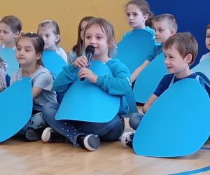 Dziewczynka w stroju kropelki mówi do mikrofonu