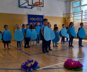 Przedszkolaki w strojach kropelek stoją grupą na koniec występu