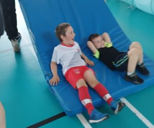 Starsze dzieci urządzają przejażdżkę na materacu przedszkolakom