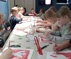  Dzieci  kolorują własnoręcznie wykonany rysunek orła farbami