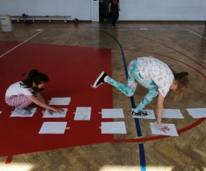 sala gimnastyczna, dwie dziewczynki pokonują tor przeszkód 