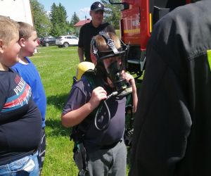 boisko szkolne, uczeń przymierza maskę strażacką