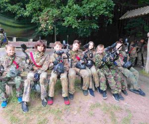 Chłopcy i dziewczęta w mundurach i z pistoletami z farbą