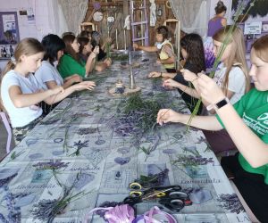 Grupa osób w stodole podczas lawendowych warsztatów.