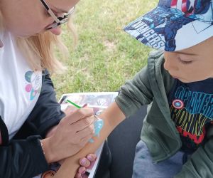 Osoba maluje rękę dziecku.