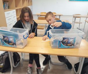 Uczennica i uczeń przy stoliku z klockami Gigo Robot