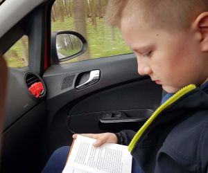 Chłopiec czytający książkę w aucie