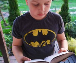 Chłopiec czytający książkę na tarasie