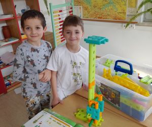 Dwóch chłopców z wieżą z klocków zbudowaną według instrukcji