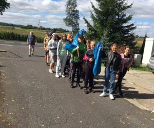Grupa uczniów z opiekunami wraca do szkoły z workami śmieci