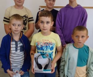 Sześciu najsympatyczniejszych chłopców stoi przy ścianie z upominkami w ręku