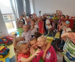 Grupa wesołych przedszkolaków, trzymających w dłoniach papierowe kółeczka