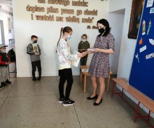 Nauczycielka wręcza nagrodę uczennicy