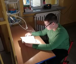 Uczeń siedzi i czyta książkę