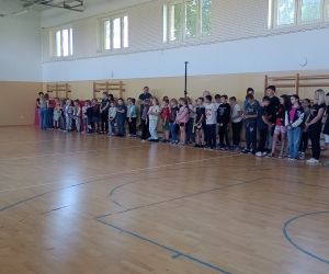 Dyrektor szkoły, nauczyciele  i uczniowie zgromadzeni  w sali gimnastycznej.