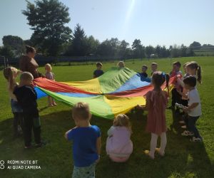 dzieci unoszą wraz z nauczycielką chustę animacyjną