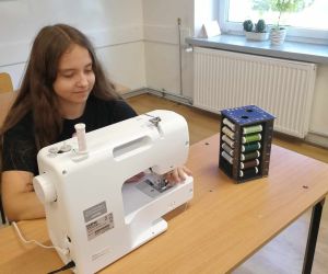 Dziewczynka szyje na maszynie do szycia