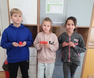 Uczniowie trzymają wydruki 3D