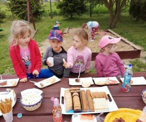 Trzy dziewczynki i chłopiec przy stole podczas poczęstunku