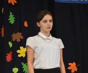 Zdjęcie przedstawia recytująca dziewczynkę.