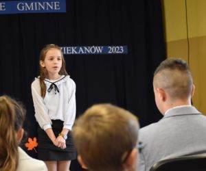 Zdjęcie przedstawia recytującą dziewczynkę.