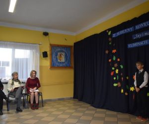 Zdjęcie przedstawia recytującego chłopca i przysłuchującą się komisję.