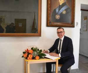 Pan Wójt wpisuje się do księgi pamiątkowej sztandaru szkoły