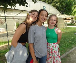 Uczennica z Polski i dwie uczennice z Portugalii z kwiatami bawełny we włosach